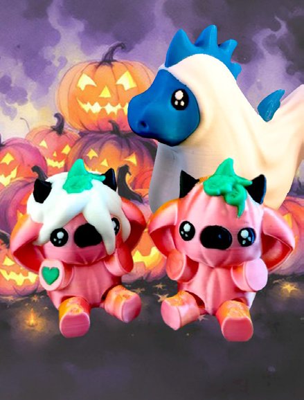 Tre 3D-printede figurer i halloween-stemning foran græskar med lys